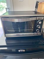 Front view of Oster toaster oven with glass door and stainless steel exterior