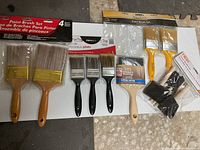 All paint brushes laid out showing variety of sizes, handles and bristle types.