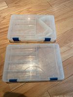 Two closed Plano clear plastic organizing kits stacked, showing secure blue latches