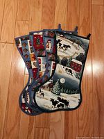 Four quilted Christmas stockings with country themed patterns, displayed overlapping on wooden floor