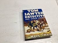 Front cover of 'Tom Sawyer Detective and Other Stories' showing colorful illustrated dust jacket with title and author.