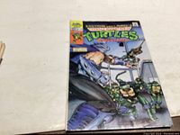 Photo of the cover front of Teenage Mutant Ninja Turtles comic book issue #2 showing the turtles and a character in blue armor.