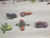 Photo showing all five space patrol vehicles arranged on a white surface, providing a full view of the lot.