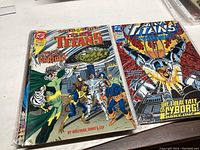 Top view of first two New Titans comic books, showing cover art and titles.