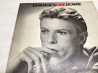 Front cover of David Bowie ChangesOneBowie vinyl record featuring a black and white close-up photograph of David Bowie.