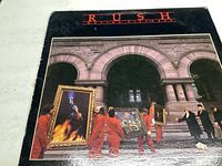 Front cover of Rush Moving Pictures album, shows artwork of figures moving paintings