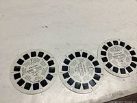 Three circular Viewmaster reels showing multiple stereo image frames and text descriptions referencing WW1 content.
