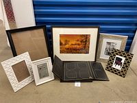 Photo showing all seven assorted picture frames including empty frames, collage frame, and framed signed photo