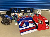 Lot contents showing all items including NHL jerseys, duffel bags, hats, water bottles, tags, and door hangers