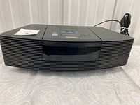 Front view of black Bose Wave Radio with speaker grill and logo visible.