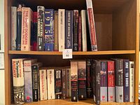 Books displayed upright on shelves showing titles focused on Canada’s military history and wartime events.