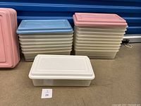 Stacked clear plastic shoe boxes with lids in pink, blue, and white colors, showing box dimensions and quantity.