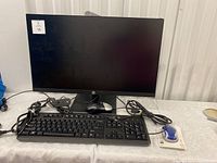 HP P244 monitor, wired keyboard, wired and wireless mice on a table