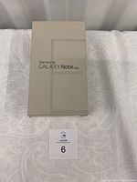 Closed Samsung Galaxy Note Edge original retail box in beige color with text Samsung GALAXY Note Edge on the cover.