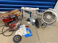 Full lot overview showing Black & Decker sander, paint stripper box, Honeywell fan, and accessories.