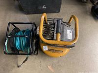 The top view of the Stanley Bostitch air compressor and adjacent hose reel with coiled blue hose.