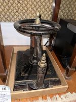 Front three-quarter view of cast iron book press on wooden floor