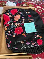 Folded antique piano shawl showing bright multicolor floral embroidery on black fabric with a note describing it as full (bed size) piano shawl.