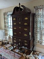 Front view of two-piece highboy showing bonnet top, drawers and hardware