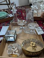 Photo showing the full set on a tray including decanter, two wine glasses, etching crystal vase, small crystal box, trinket box with gold flower, small dish with decanter stoppers.