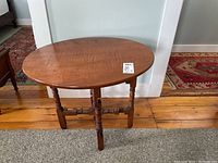 Full view of oval wood gateleg table showing turned legs and oval top