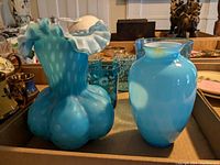 Two blue glass vases side by side showing their shape and color patterns.