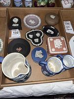 Photo showing assortment of Wedgwood Jasperware items including pitchers, trinket boxes, pin dishes, and a small black clock.