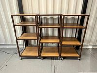 Front view of three adjustable shelving units with steel frames and wooden shelves, showing full height and shelf spacing.