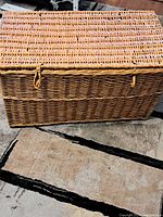 Wicker chest with closed lid showing the woven pattern and closure loops
