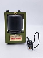 Front view of the entire tumble polisher with green metal frame, black jar, and power cord.