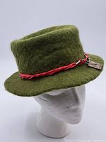 Green felt vintage Italian hat on a mannequin head showing the overall shape and texture.