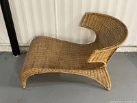 Side profile of wicker chaise lounge showing overall curved shape