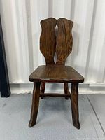 Front view of the vintage wooden chair showing the two-piece sculpted backrest and solid seat.