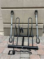 Front view showing standing rack with two vertical wheel supports and two Thule adaptors with black securing loops.