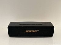 Front view of Bose SoundLink Mini speaker showing black mesh grille with Bose logo.