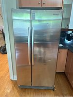 Front view of KitchenAid double door stainless steel refrigerator showing marks and dents.