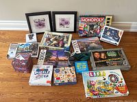 Wide view of puzzles, board games, and framed art arranged on floor