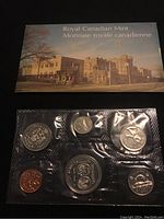 View of the front of the Royal Canadian Mint display folder and six sealed coins in blister packaging, showing the coins' details and arrangement.