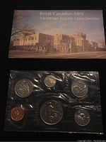 Front photo of 1975 Canadian uncirculated coin set sealed in original plastic with branded card from Royal Canadian Mint showing mint building and Canadian flag.