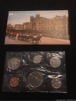 Front view of sealed plastic holder with six Canadian coins displayed and Royal Canadian Mint postcard atop.