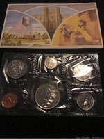 Photo showing six uncirculated Canadian coins from 1983 sealed in plastic packaging alongside a colorful informational card with images of Canadian landmarks.