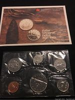 Two photos of the sealed 1985 Canadian uncirculated coin set with mint booklet, showing both front and back of the packaging containing six coins.