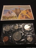 Set of seven 1986 Canadian uncirculated coins sealed in plastic with informational booklet showing Canadian landmarks and artworks.