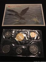 Three 1990 Canadian uncirculated coin sets shown in sealed plastic blister packs with original envelope packaging and a scenic card showing geese in flight over water for one set.