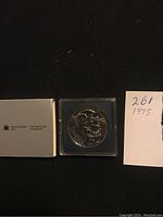 Front and back images of the 1995 Canadian uncirculated silver dollar coin in plastic case with original Royal Canadian Mint packaging and handwritten note.
