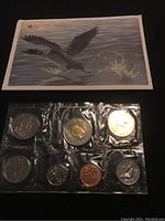 Photo of the 1998 uncirculated Canadian coin set sealed in plastic with seven coins and a color print envelope showing a duck executing a water splash behind it.