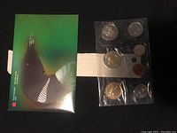 Front view of Canadian Mint green envelope with uncirculated coins set in clear plastic pouch.