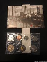 Front side of sealed plastic packaging containing seven 2002 Canadian uncirculated coins with a historical Canadian Mint image behind.