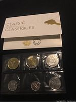 Front of Royal Canadian Mint envelope with six coins in individual plastic sleeves displayed below the envelope, showing front designs and denominations of the coins.