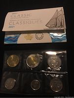 Front view of the coins in blue and white packaging, showing six uncirculated Canadian coins in clear plastic holders.